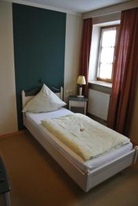 a bed in a room with a window and a bed sidx sidx sidx at Hotel Daimerwirt in Moosinning