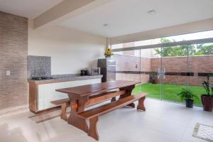 a kitchen with a wooden bench and a table at Residencial Onda Azul in Bombinhas