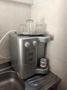 a coffee machine with glasses on top of it at Casa das Flores in Guaramiranga