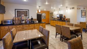 a restaurant with tables and chairs and a kitchen at Best Western East El Paso Inn in Clint