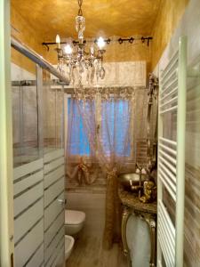 een badkamer met een wastafel en een kroonluchter bij Sweet Home in Castelletto sopra Ticino