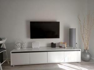 een wit entertainmentcentrum met een televisie aan de muur bij Apartamento Vega in Baena