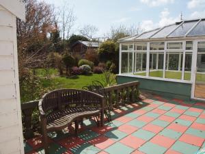 a bench sitting on a patio with a greenhouse at Chez Sé in Drogheda