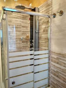 een douche met een glazen deur in een badkamer bij Sweet Home in Castelletto sopra Ticino +44 foto's
