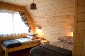 ムジャシフレにあるDomki Tatrzańskie Kącinaのベッド2台 木製の壁の部屋