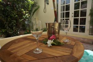 a table with two wine glasses and flowers on it at Wonders Boutique Hotel in Oranjestad