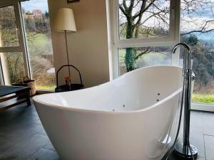 a white bath tub in a room with windows at Die Mayerei in Kitzeck im Sausal