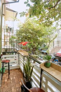 a balcony with a lot of plants and tables at KemKay Homestay in Hanoi