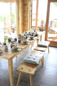 VallanesにあるMóðir Jörð Organic Farm Guesthouse in Vallanesの長い木製テーブル(皿、鉢付)