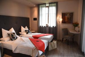 ein Hotelzimmer mit 2 Betten und einem Schreibtisch in der Unterkunft Relais Villa Quercia in Tassul