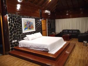 a bedroom with a bed and a living room at Hotel Villa Sirena in Vichayito