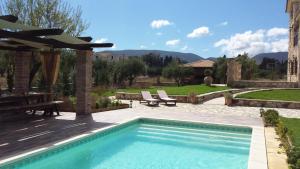 a swimming pool with two chairs and a table at Palazzo Di P Villa, World 5th Award in Kalpaki