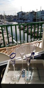 tres copas de vino sentadas en una bandeja en un balcón en Port Ducal, en Empuriabrava