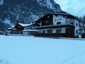 a building in the snow in front of a mountain at Biancas Ferienwohnung im Haus Roswitha in Tumpen