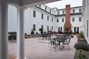 GrotonにあるThe Groton Innの建物の前にテーブルと椅子付きのパティオ