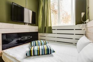 a bedroom with a bed with a television and a pillow at Loft Hotel H11 in Moscow