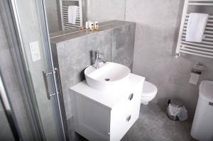 un bagno bianco con lavandino e WC di Apartament IKAR - 2 pokojowy przy morzu z balkonem a Pobierowo Altre 27 foto