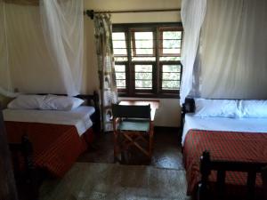 
a bedroom with a bed and a window at Masai Paradise Cottages in Diani Beach
