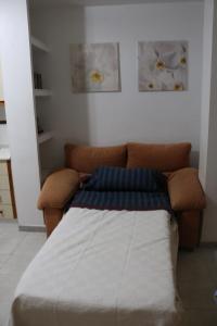 プエルト・デ・マサロンにあるAlojamiento en Puerto Solのソファ付きの部屋のベッド1台