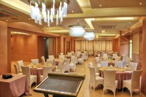 um salão de banquetes com mesas brancas e cadeiras brancas em New Dawn Plus em Cagayan de Oro