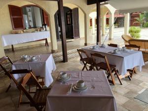 Duas mesas com toalhas de mesa brancas num pátio em Black Point Beach Club em Maricá