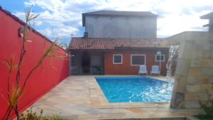 a swimming pool in front of a house at Casa de Praia Itanhaém in Itanhaém