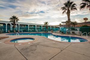 una piscina con palme di fronte a un motel di St. George Inn and Suites a St. George