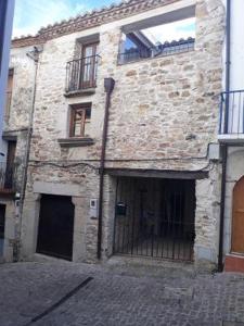 - un ancien bâtiment en briques avec une porte devant dans l'établissement El Cargol, à Xert