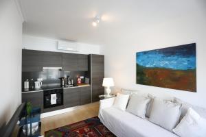 a living room with a white couch and a kitchen at Central Lisbon Luxury Apartment in Lisbon