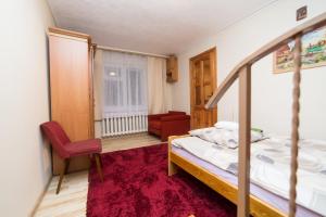 a bedroom with a bed and a chair and a window at Domek na Kaszubach - Cały dla Ciebie! in Lipnica