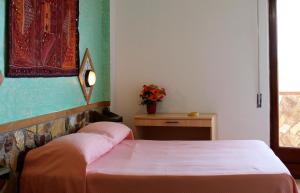 a bedroom with a bed and a table with flowers at Hotel Diana in Ustica