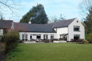 ein weißes Haus mit einem Picknicktisch davor in der Unterkunft Brown Trout Golf & Country Inn in Aghadowey