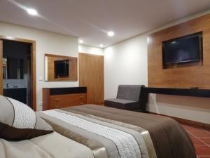 a bedroom with a bed and a tv on the wall at Casinha dos Cubos in Geres