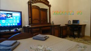 Zimmer mit großem Spiegel und TV in der Unterkunft Apartment vake-saburtalo in Tbilisi City