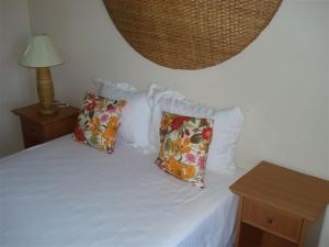 a white bed with two pillows on top of it at CostaSol Pipa Chalés in Pipa