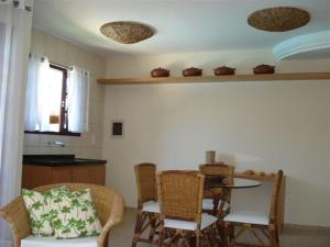 a room with a table and chairs and a kitchen at CostaSol Pipa Chalés in Pipa