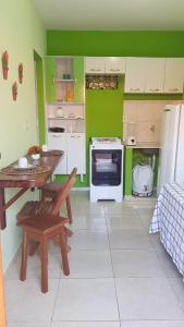 - une cuisine avec des murs verts, une table et une cuisinière dans l'établissement Casas Barra Sol, à Barra Grande