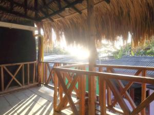 a porch of a straw hut with the sun shining at Rancho Mar in Rincón
