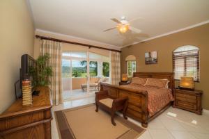 a bedroom with a bed and a ceiling fan at Stay In CR Los Sueños Condos in Jacó