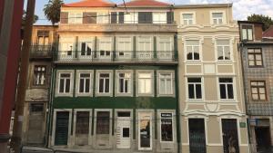een hoog groen en wit gebouw met een balkon bij Oporto City View - Santa Catarina in Porto