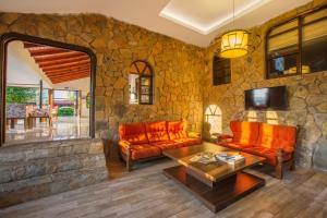 een woonkamer met oranje meubels en een stenen muur bij La Finca Hotel in Alanya