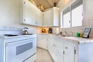 a kitchen with white cabinets and a sink at Marebello in Fort Bragg