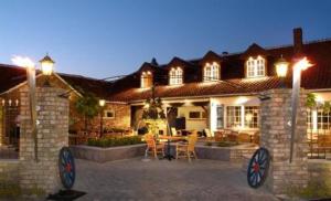 a house with a patio with a table and chairs at Hotel Restaurant D'Hofstee in Zuienkerke