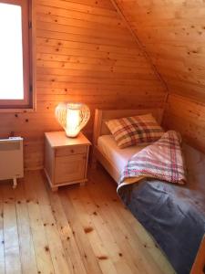 a bedroom with a bed in a log cabin at Durmitorska kuća in Žabljak