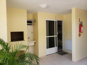 um quarto com uma porta de vidro deslizante e uma televisão em Pousada Barra Nativa em Florianópolis