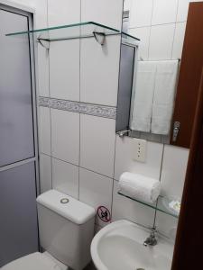 um banheiro com um vaso sanitário, uma pia e um espelho em Pousada Barra Nativa em Florianópolis mais 18 fotografias