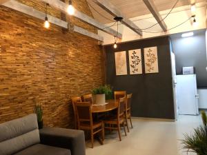 comedor con mesa, sillas y pared de ladrillo en Apartament - Loft, en Piła