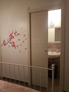 ein Badezimmer mit einer Dusche mit rosa Blumen an der Wand in der Unterkunft B&B La Perla Bianca in Sassari