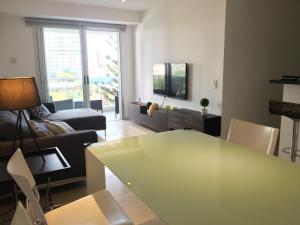 sala de estar con mesa y sofá en Apartamento Punta del Este Arenas, en Punta del Este