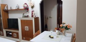 a dining room table with a white table cloth and flowers at Apartamento Nerja Beach in Nerja